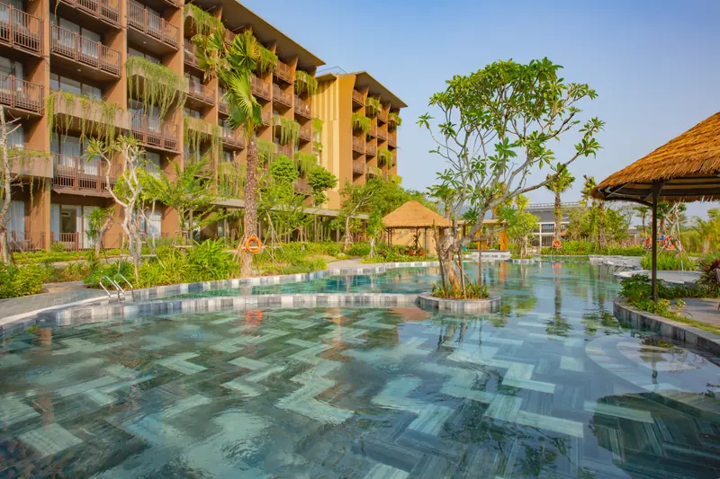 Bể bơi ngoài trời lát đá xanh trước tòa nhà phòng nghỉ nhiều tầng