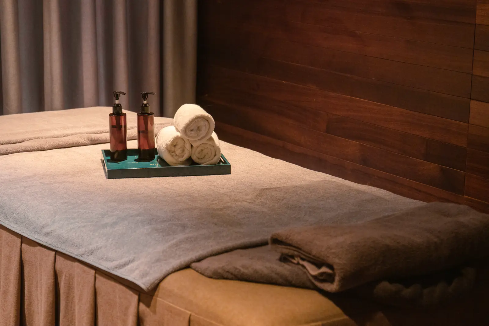 Giường massage trải khăn, khay tinh dầu trong phòng spa ốp gỗ ở La Zen Spa – nơi dùng suất spa 30 phút, thay được bằng thiền chuông Mandala Kim Bôi trong gói 2N1Đ