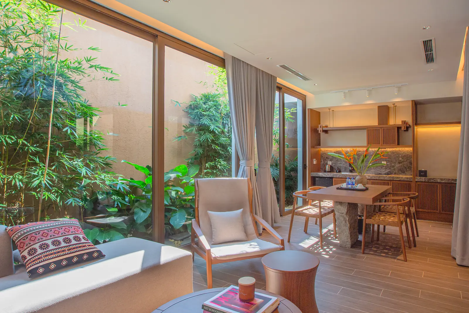 Phòng khách villa La Yên với sofa, ghế thổ cẩm và bàn ăn nhìn ra sân