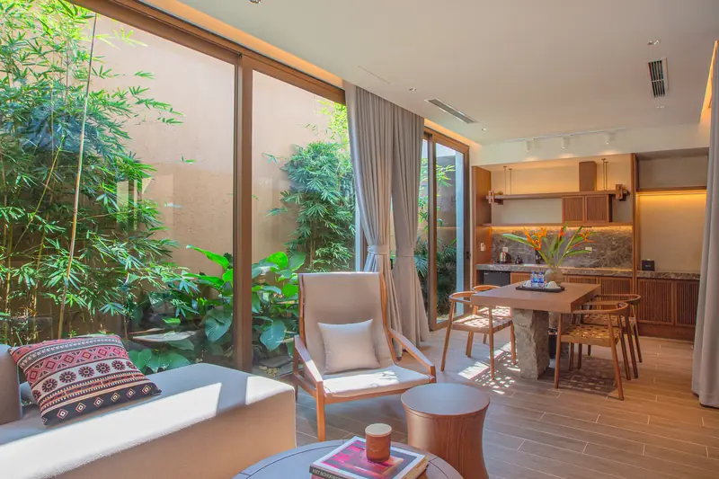 Phòng khách villa La Yên với sofa, ghế thổ cẩm và bàn ăn nhìn ra sân