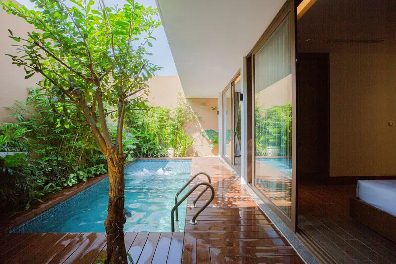 Bể bơi riêng chạy dọc phòng ngủ villa La Yên, cây xanh trong sân